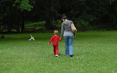 woman holding a little boys hand and walking